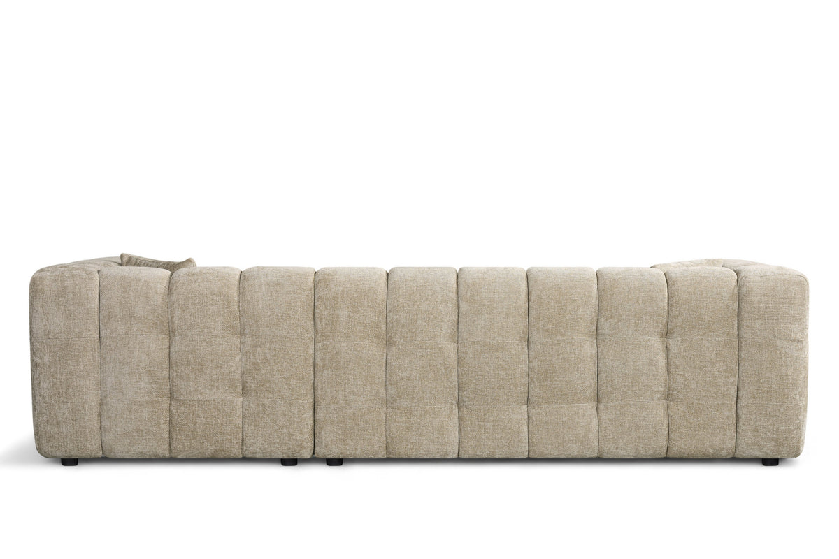 An L-shaped tufted sofa with right hand facing chaise end section, upholstered in beige chenille fabric