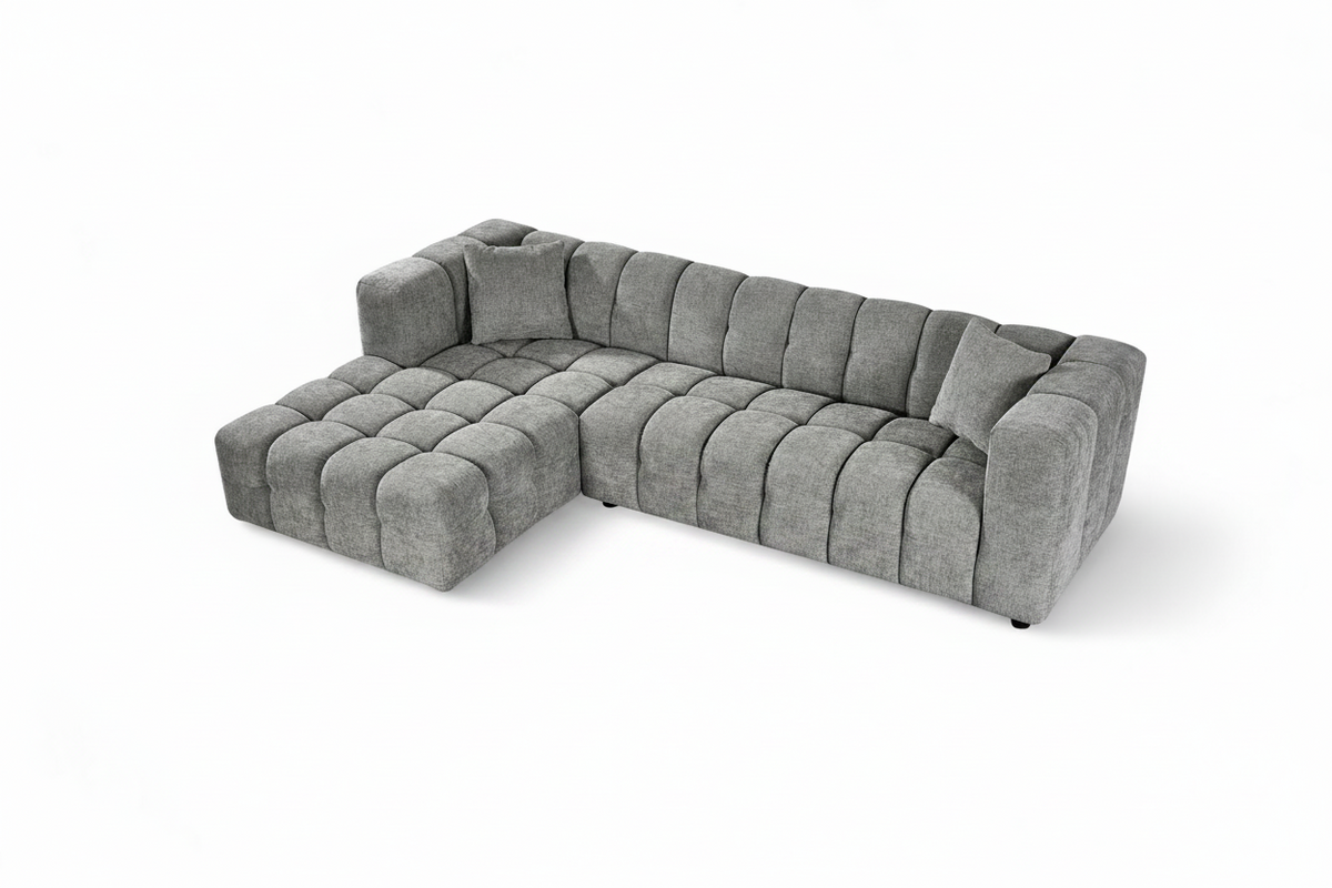 An L-shaped tufted sofa with left hand facing chaise end section, upholstered in grey chenille fabric
