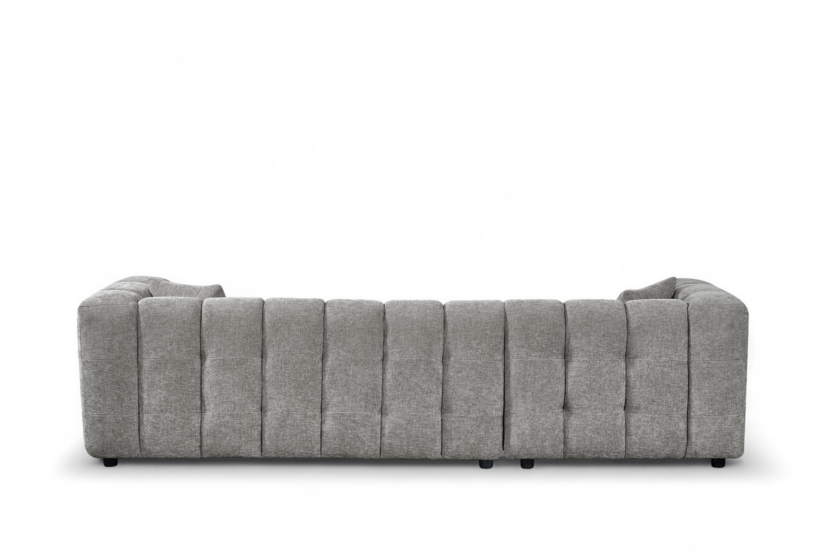 An L-shaped tufted sofa with right hand facing chaise end section, upholstered in grey chenille fabric