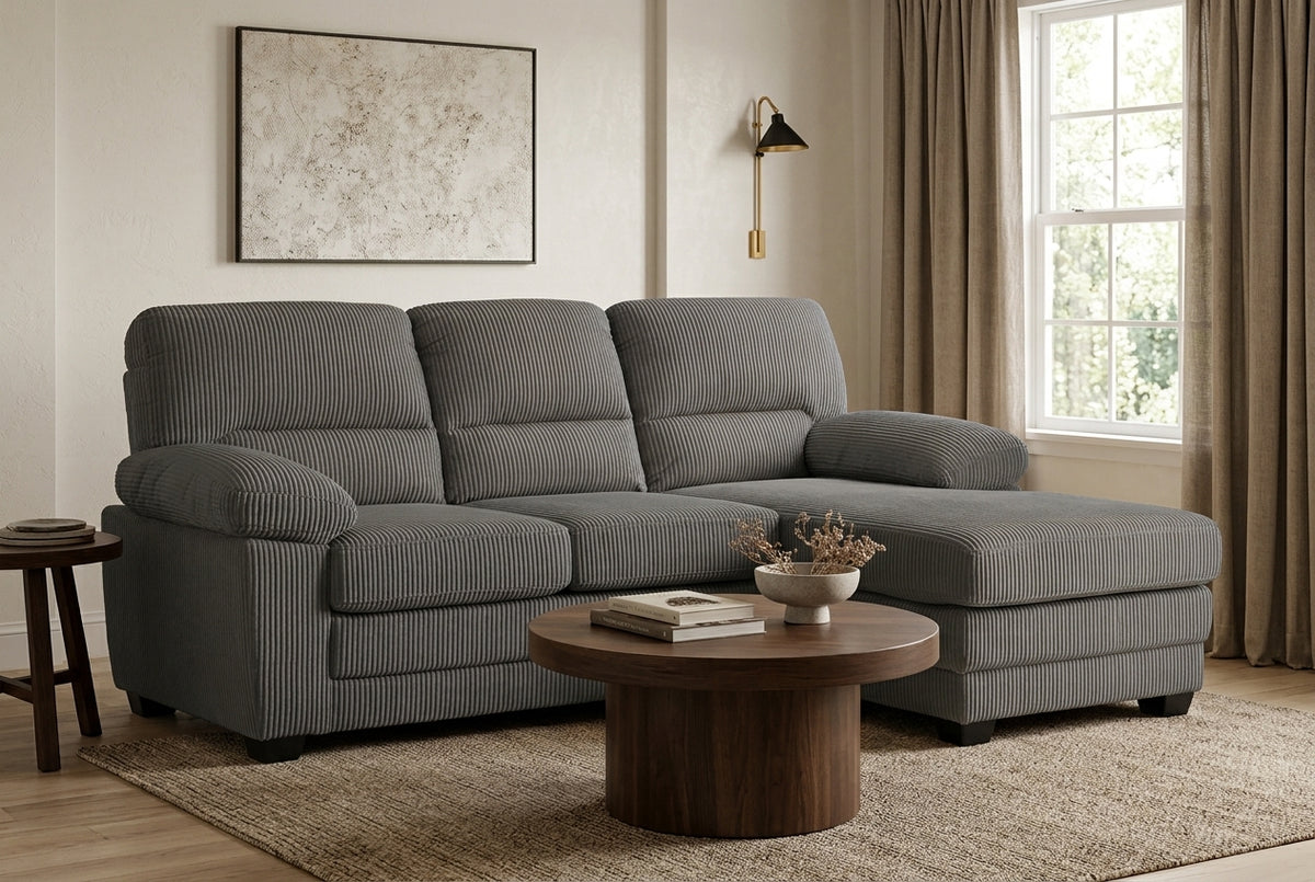 l-shaped sofa with right hand facing chaise section, upholstered in grey jumbo cord with wooden legs, in a living room setting.