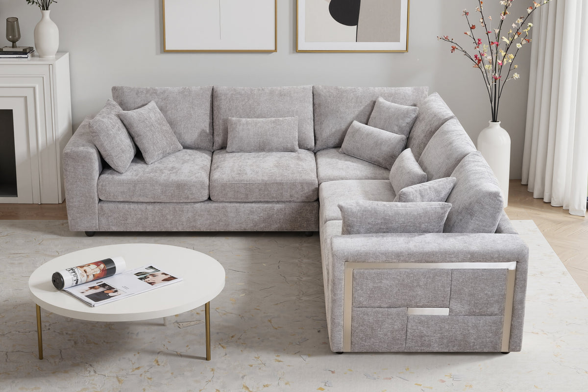 modern grey corner sofa in chenille fabric upholstery with stylish metal trim detail on the sides in a living room