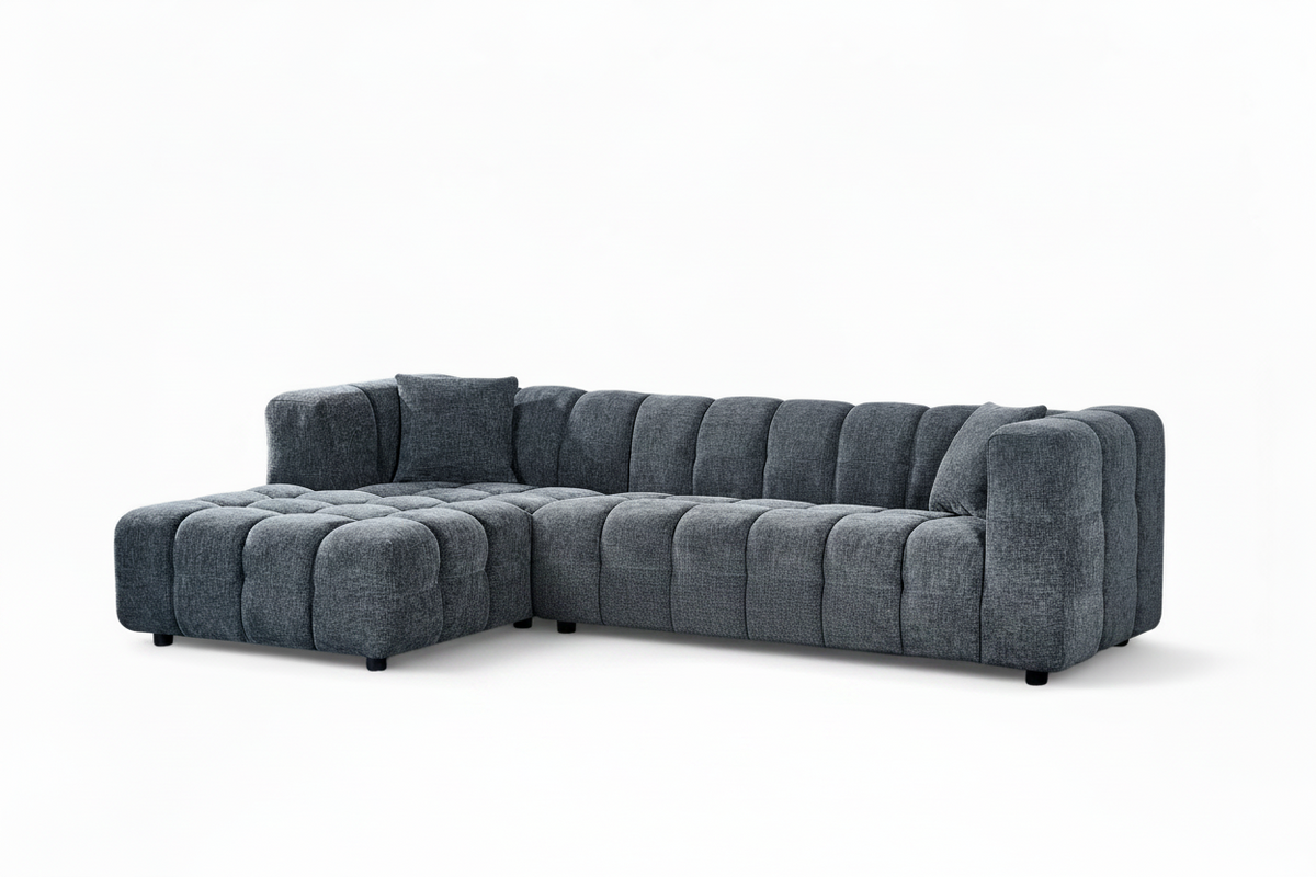 An L-shaped tufted sofa with left hand facing chaise end section, upholstered in pale blue chenille fabric