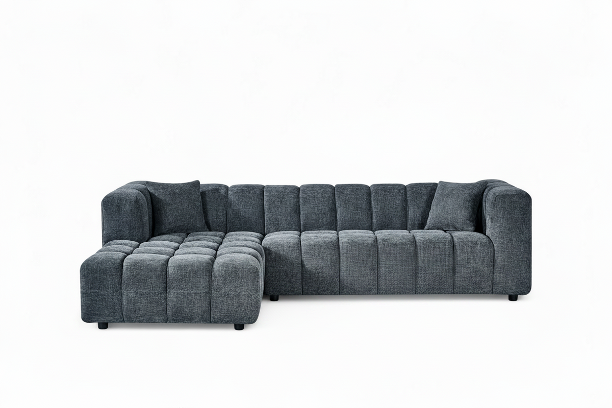 An L-shaped tufted sofa with left hand facing chaise end section, upholstered in pale blue chenille fabric