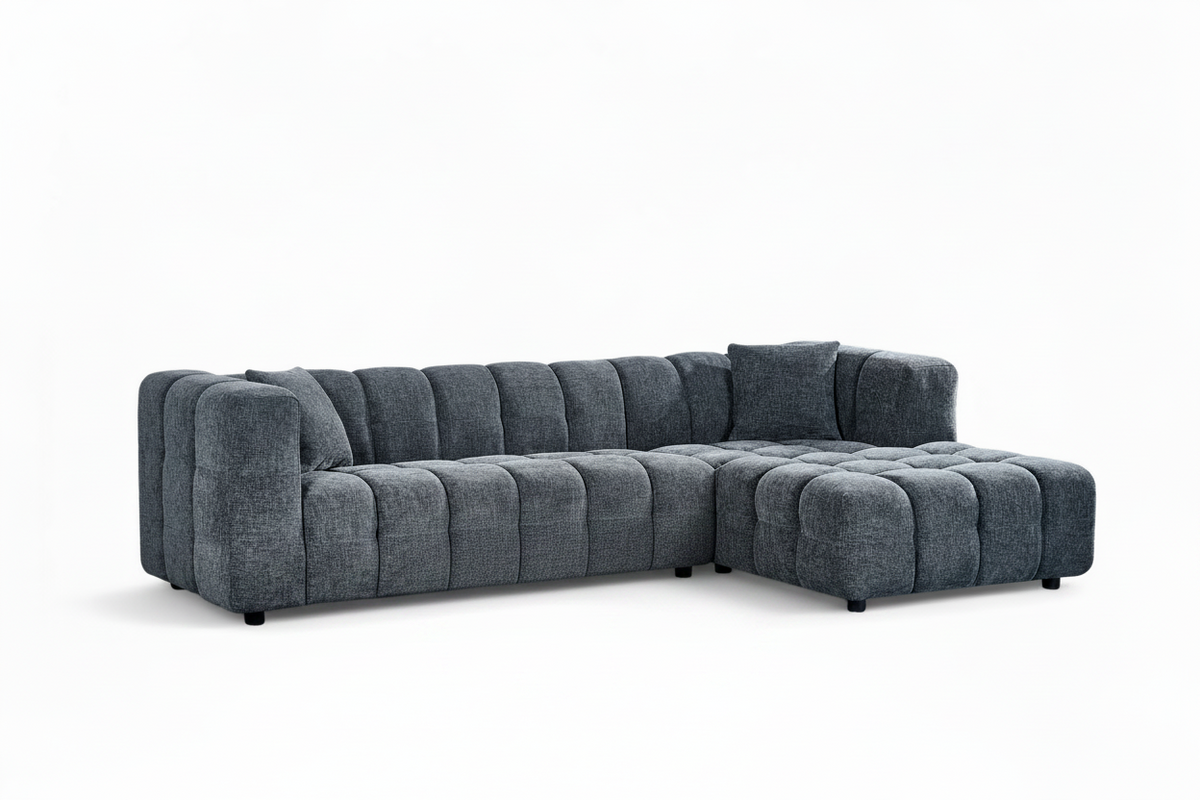 An L-shaped tufted sofa with right hand facing chaise end section, upholstered in pale blue chenille fabric