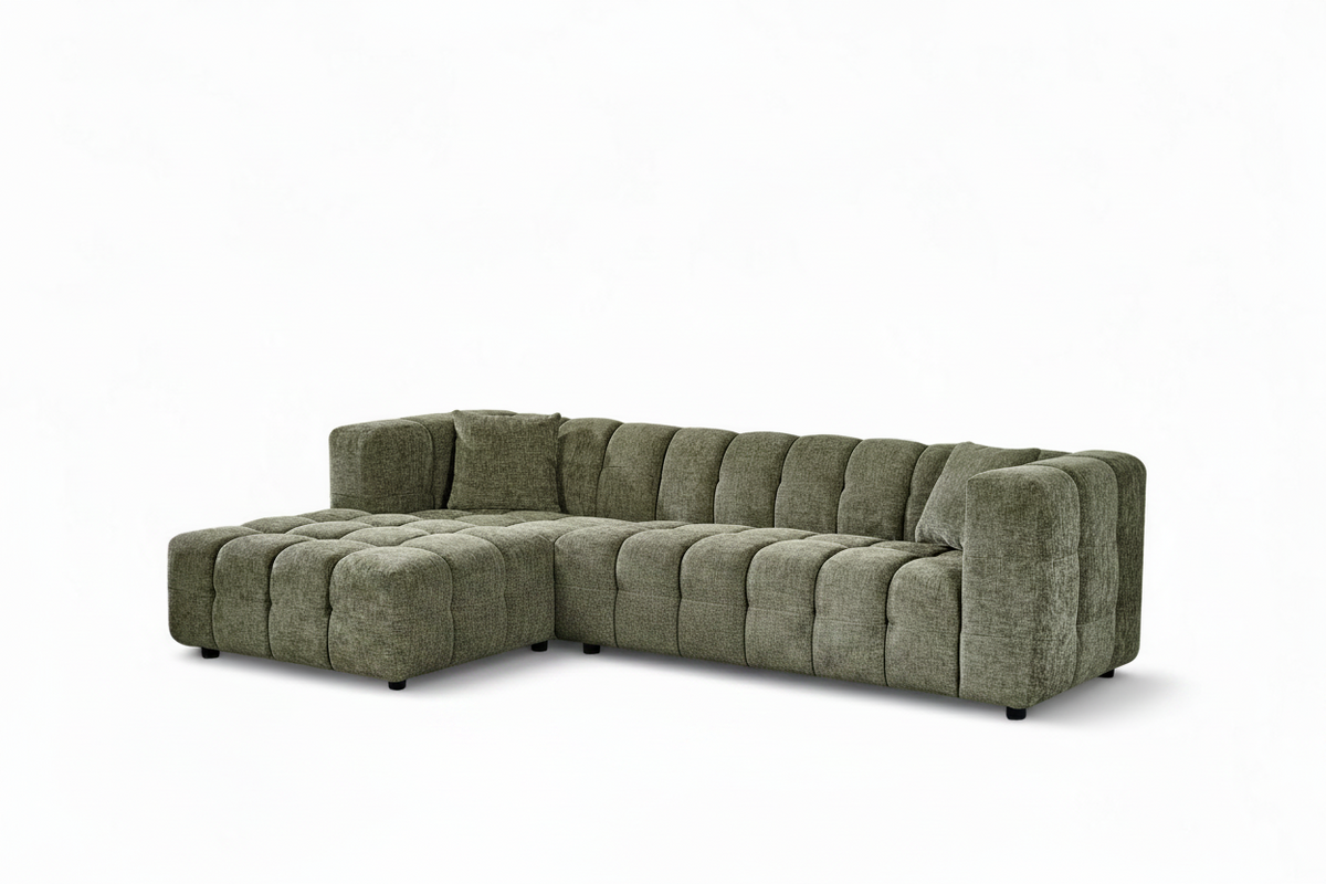 An L-shaped tufted sofa with left hand facing chaise end section, upholstered in textured sage green chenille fabric