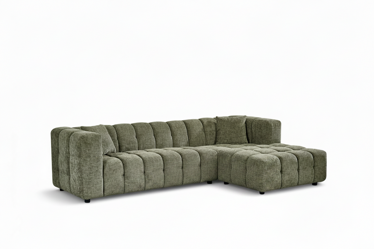 An L-shaped tufted sofa with right hand facing chaise end section, upholstered in textured sage green chenille fabric